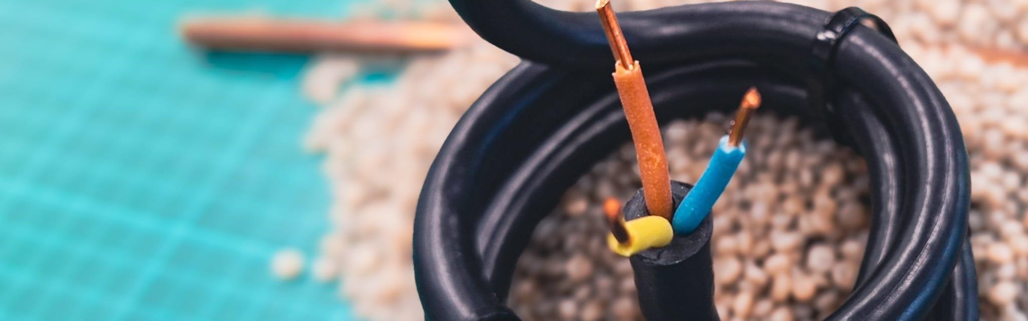 Close-up of recycled electric cables with exposed wires in various colors.
