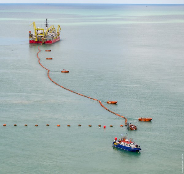 Vue aérienne d'un bateau de service et d'une plateforme offshore dans une mer calme.
